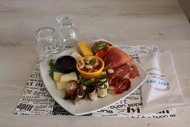 Un piatto di antipasti della casa: prosciutto, salame, formaggi, verdure grigliate, fagioli e bruschetta