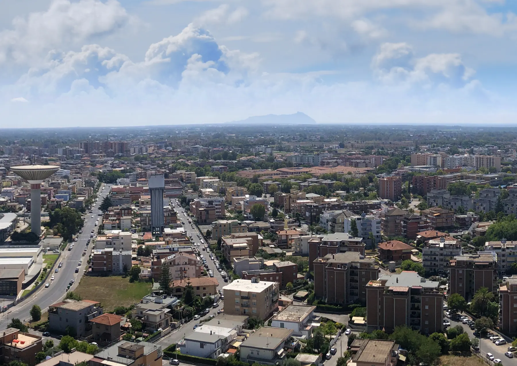 Latina vista dall'alto: i palazzi, il serbatoio dell'acqua e, sull'orizzonte, il Circeo