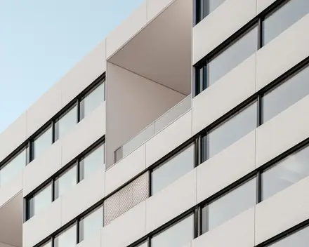 La facciata bianca di un condominio moderno, con le logge incassate