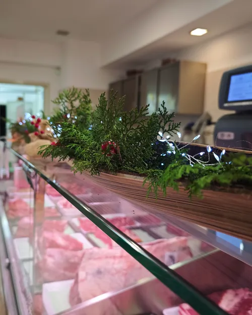 Il bancone della macelleria, con la carne in vetrina e un ramo di abete sopra il vetro