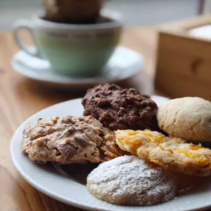Biscotti misti su un piatto, accanto a una tazza