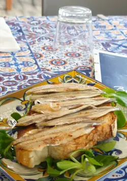 Bruschetta di alici marinate su un letto di insalatina
