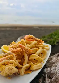 Frittura di calamari e gamberi, con la spiaggia alle spalle