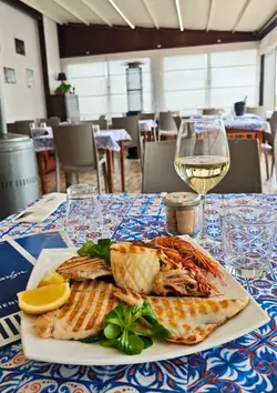Grigliata di pesce e un calice di bianco, nella veranda