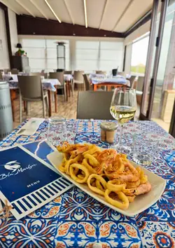 Frittura di calamari e gamberi accanto al menù del Blu Marlyn