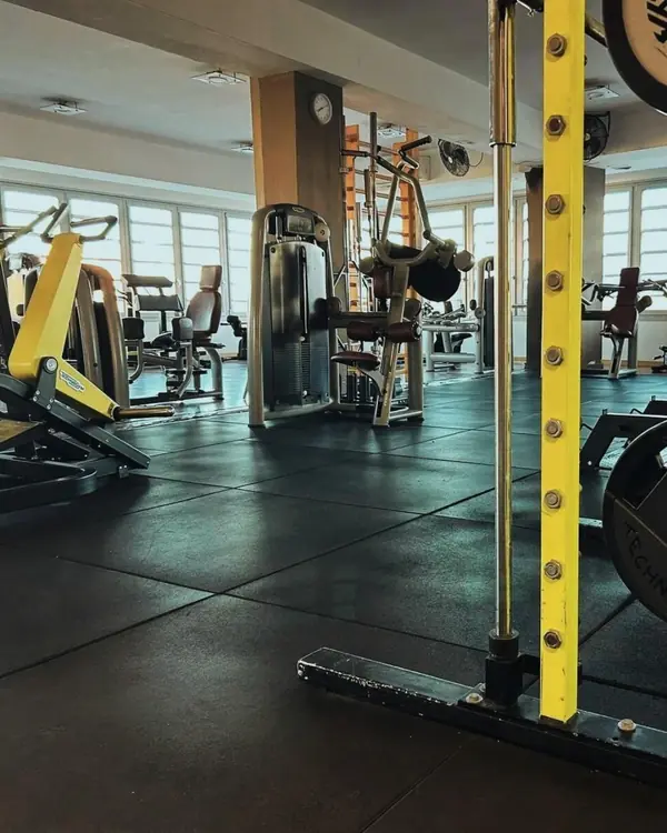 La sala pesi di Body Planet, con il rack giallo in primo piano e le finestre sul fondo