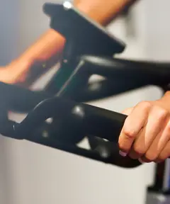 Le mani sul manubrio di una bike da indoor cycling