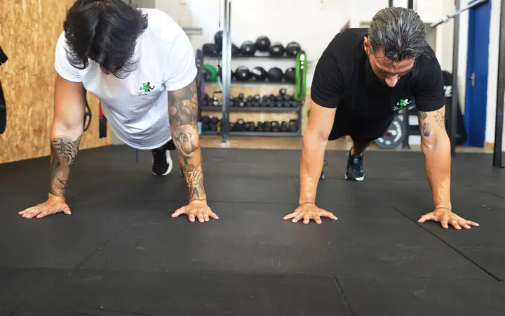 Due istruttori di Body Planet fanno piegamenti sulle braccia