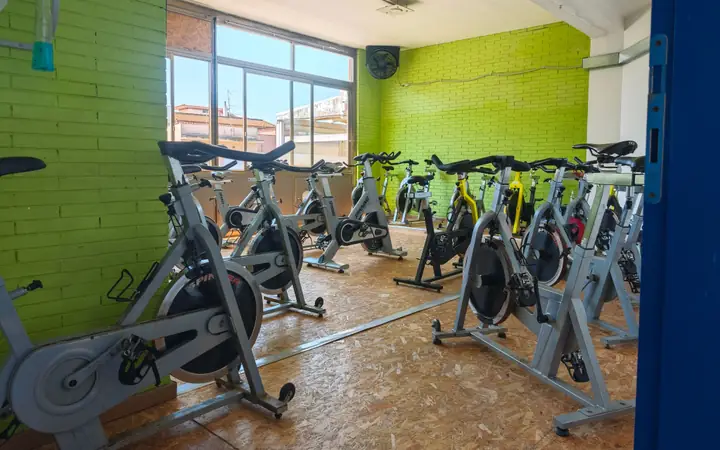 La sala dell’indoor cycling, con le bike davanti alla parete verde