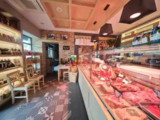 La macelleria: il banco frigo con le carni e gli scaffali dei prodotti