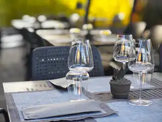 Calici e tovagliette su un tavolo apparecchiato del dehors