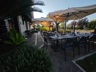 Il dehors con gli ombrelloni e le palme, nella luce del pomeriggio