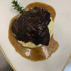 Carne brasata con il suo sugo, su un letto di purè