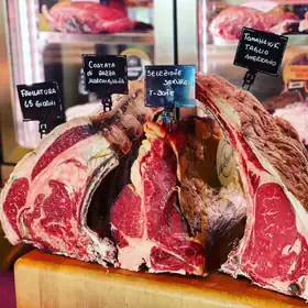 Tagli frollati sul banco con i cartellini: frollatura 65 giorni, costata di razza marchigiana, T-bone selezione Sakura, tomahawk taglio americano