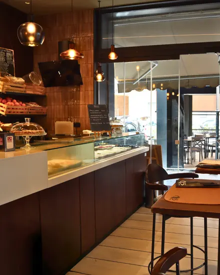 Il bancone del bar con la vetrina dei dolci e le luci a sospensione