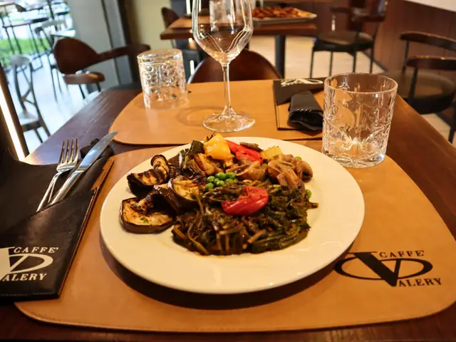 Un piatto di verdure: melanzane grigliate, cicoria, funghi, piselli e pomodorini