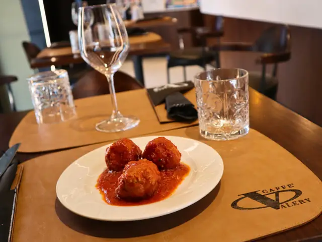 Polpette al sugo sulla tovaglietta con il logo di Caffè Valery, in sala
