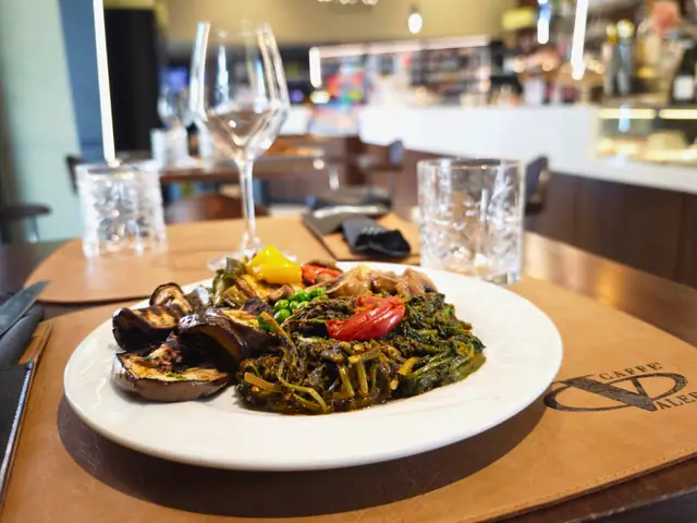 Il piatto di verdure sul tavolo, con il bancone del bar sullo sfondo