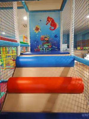 Il percorso morbido del parco giochi, con i rulli rossi e blu e il cavalluccio marino dipinto sulla parete