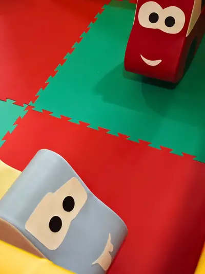 Due macchinine imbottite sui tappeti rossi e verdi del parco giochi