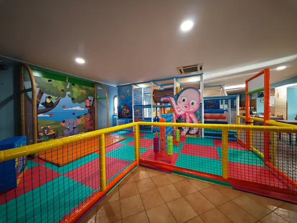 La sala del parco giochi, con i recinti colorati e il polpo dipinto sulla parete