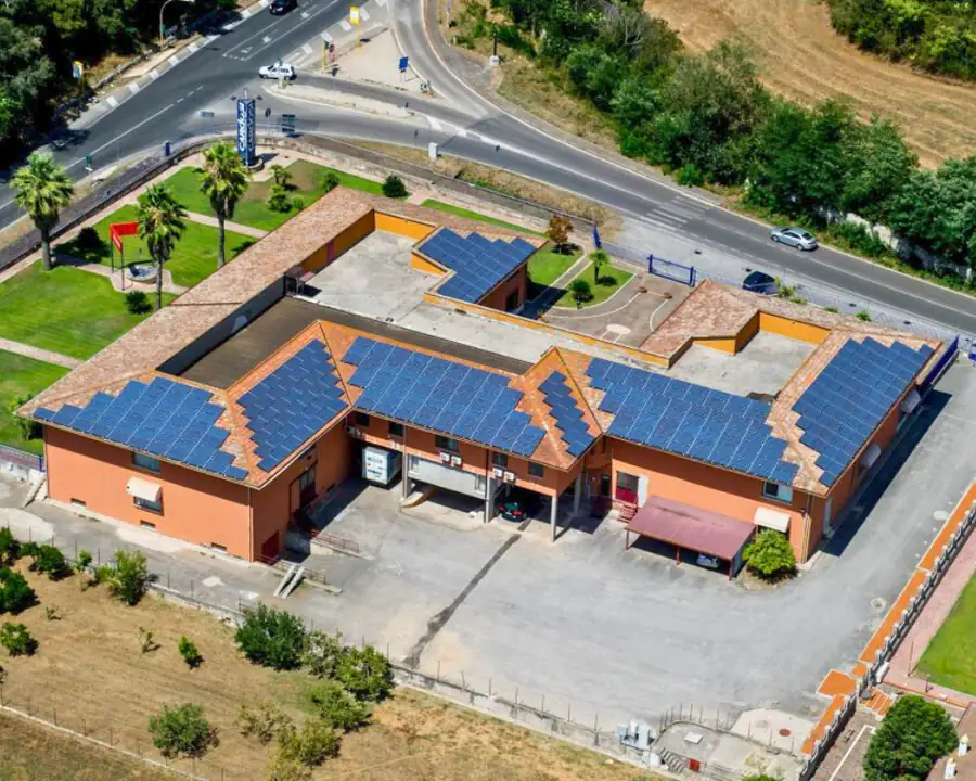 La sede vista dall'alto: l'edificio a corte con il tetto coperto di pannelli solari, accanto alla strada
