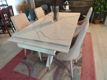 Tavolo con piano effetto marmo e sedie imbottite chiare