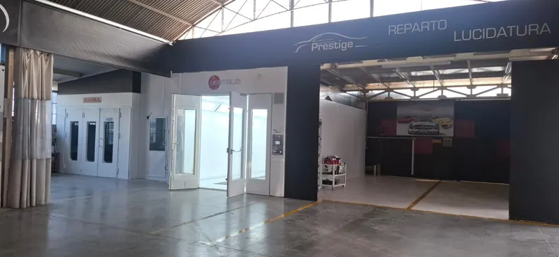 Il forno di verniciatura della carrozzeria, con le porte vetrate aperte e il marchio Prestige in alto