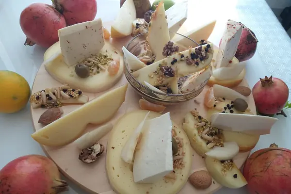 Formaggi a scaglie e a fette con noci, pinoli, mandarini e melagrane