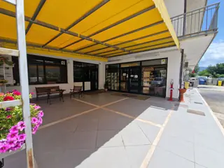 Il portico del punto vendita, con la tenda gialla e i vasi di fiori
