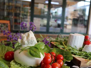 Una burrata con basilico, pomodorini e ricotte sul tavolo all’ingresso