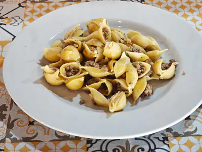 Conchiglie al ragù bianco, sulla tovaglia a maioliche