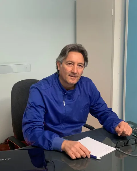 Il Dott. Gian Luca Del Prete, in casacca blu, seduto alla scrivania del suo studio