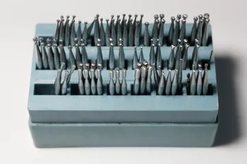 Frese per il trapano del dentista, in file ordinate in un portafrese azzurro