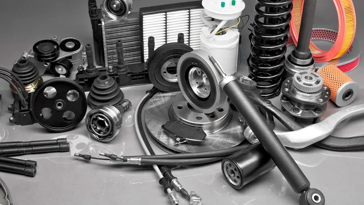 Ricambi per auto su un piano grigio: ammortizzatore, dischi, pulegge, filtri, giunti e cavi