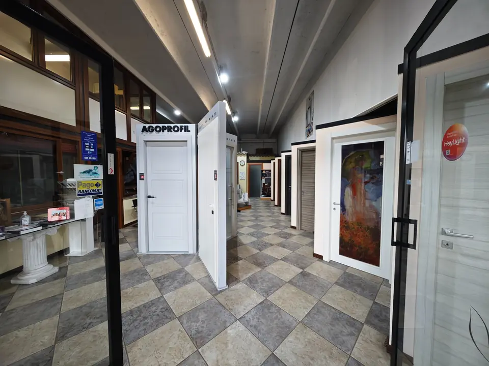 Lo showroom di Duegi Infissi ad Aprilia: porte in esposizione ai due lati del corridoio