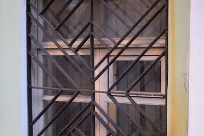 Una grata di sicurezza a disegno geometrico davanti a una finestra