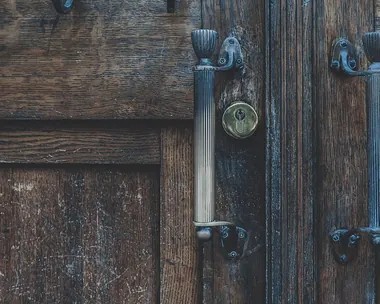 Porta a due ante in legno scuro con le maniglie in ferro