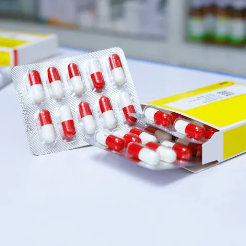Capsule bianche e rosse accanto alla loro confezione