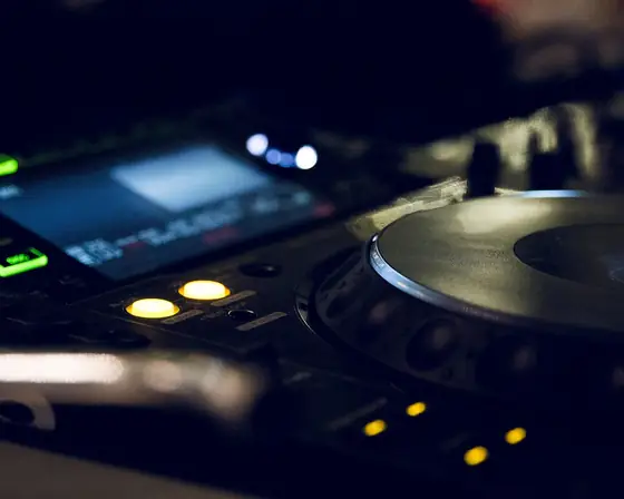 Un lettore per DJ con i pulsanti illuminati, nella penombra