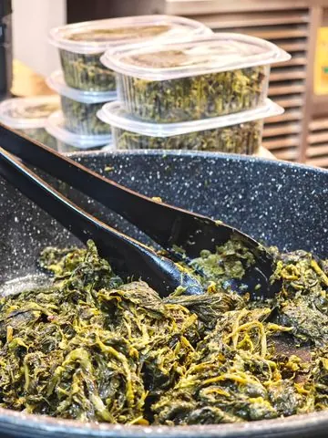Verdura ripassata in padella e, dietro, le vaschette già pronte