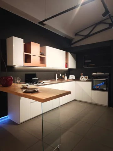 Cucina bianca con penisola in legno sostenuta da una lastra di vetro