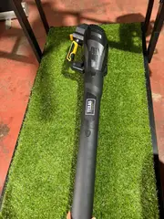 Un soffiatore a batteria su un tappeto d’erba sintetica