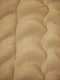Gelato color crema lisciato a onde nella vaschetta
