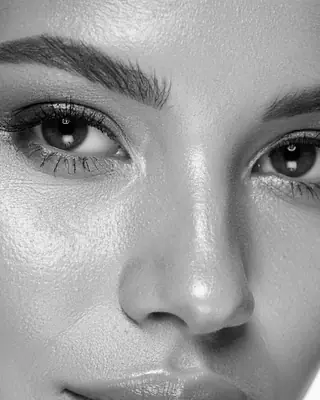 Il viso di una donna da vicino, con sopracciglia e ciglia curate