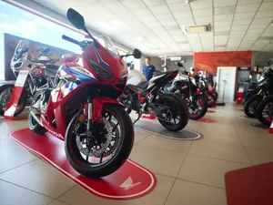 Una Honda sportiva rossa sulla sua pedana, con le altre moto dietro
