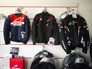 Giacche da moto Honda e Alpinestars appese in negozio