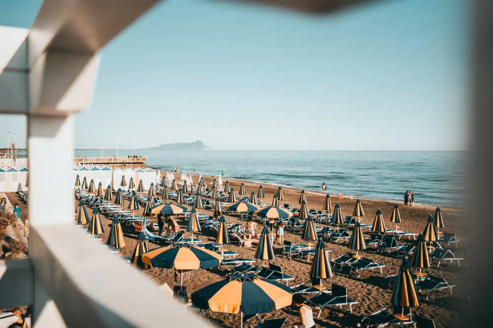 Gli ombrelloni dello stabilimento sulla spiaggia, con il Circeo all’orizzonte