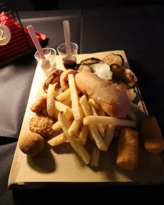 Un tagliere di fritti misti con patatine, verdure pastellate e salse