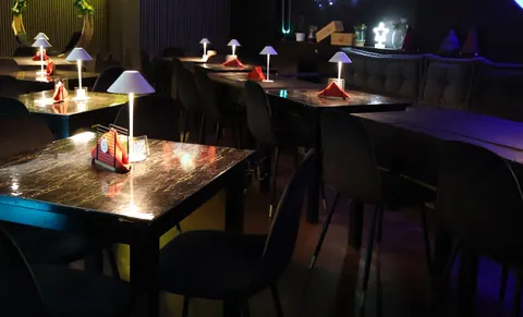 La sala di sera, con le lampade accese sui tavoli e le luci sulle pareti